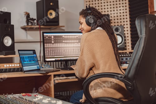 Preview: Woman blogger records online podcast using laptop, headphones and microphone in music studio