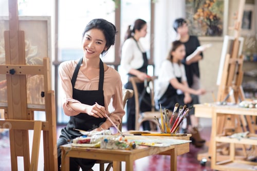 Preview: Young woman painting in art class