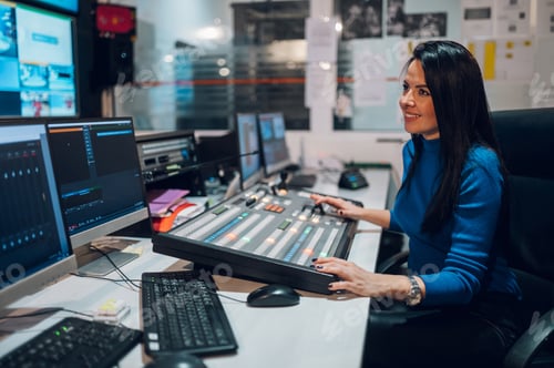 Preview: Middle aged woman using equipment in control room on a tv station