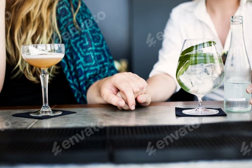 Preview: Two people enjoying drinks at a stylish bar