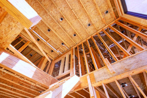 Preview: An unfinished wood frame is being constructed for new house construction with wooden trusses a post