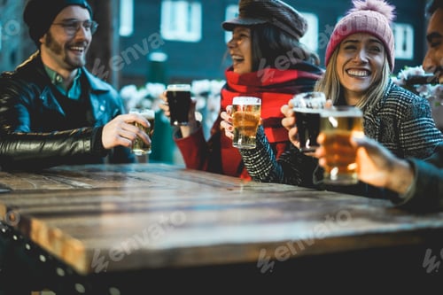 Preview: Young people having fun drinking beer at pub restaurant - Focus on right girl holding glass