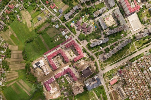 Preview: Aerial view of town or city with rows of buildings and curvy streets in summer.