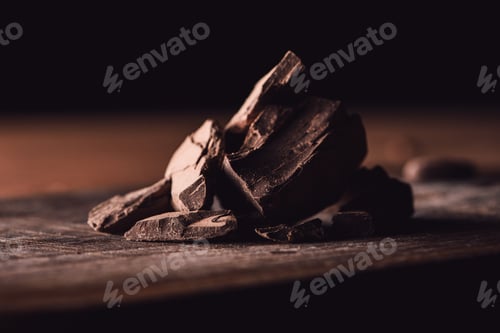Preview: closeup shot of pieces of dark chocolate on wooden tabletop