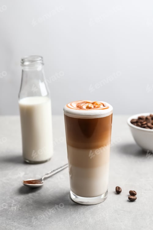 Preview: Glass with delicious caramel latte on table