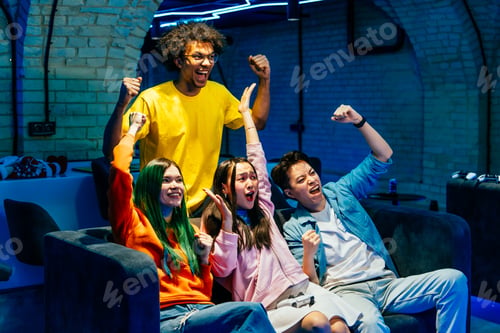 Preview: Multiethnic group of young friends playing videogames at home