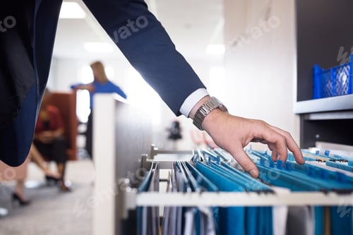 Preview: Close-up of man looking through files in cabinet