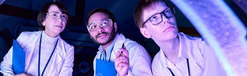 Preview: Banner, Futuristic Exploration: Diverse-Age Scientists Investigate Device in Neon-Lit Science Center