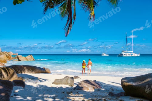 Preview: Anse Georgette Praslin Seychelles, young couple men and woman on a tropical beach during a luxury