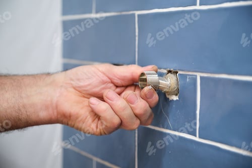 Preview: Unrecognizable senior plumber installing water tap in bathroom.