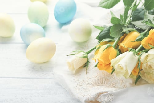 Preview: Happy Easter. Easter eggs on rustic table with white and yellow roses. Natural dyed colorful eggs in