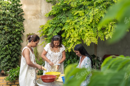 Preview: women shelling corn for the family dinner.