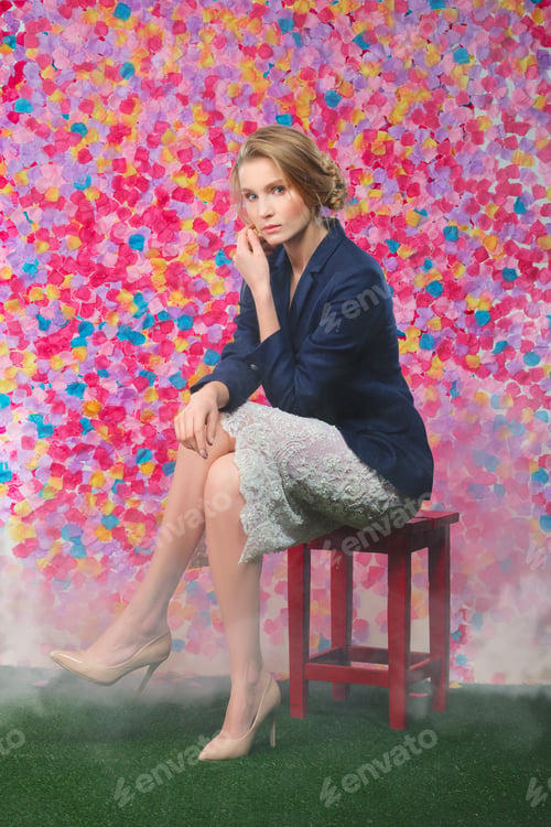 Preview: Full length portrait of cute girl in blue jacket and lace skirt sitting on chair