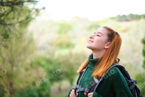 Preview: Female hiker breathing fresh air in the mountain.