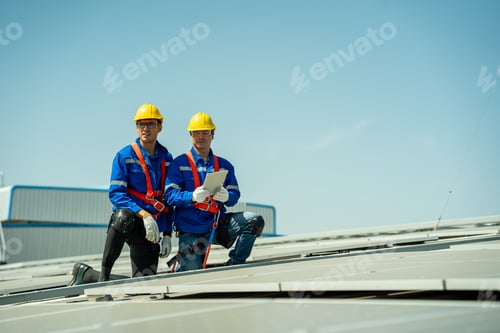 Preview: Engineer service check installation solar cell on the roof of factory.