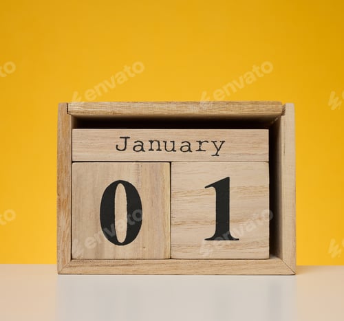 Preview: Wooden calendar made of cubes on a yellow background. Date January 1st, beginning of the year