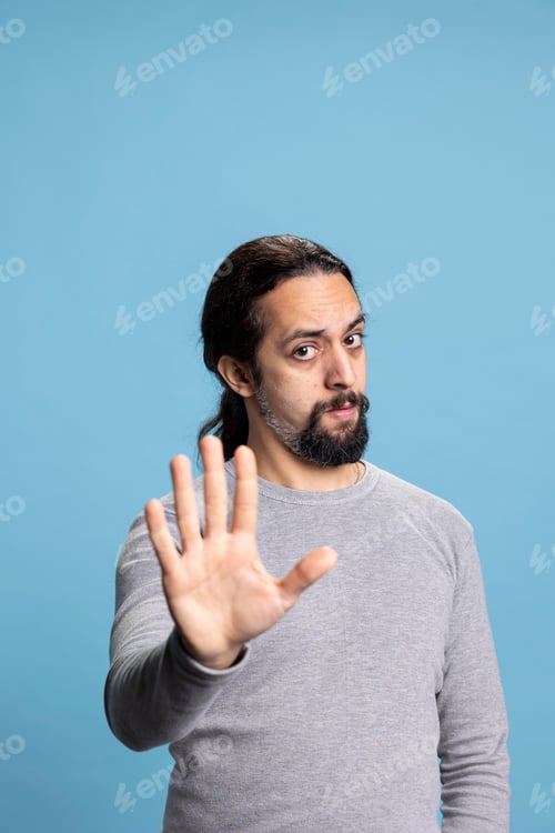 Preview: Young serious person expressing rejection with his palm raised