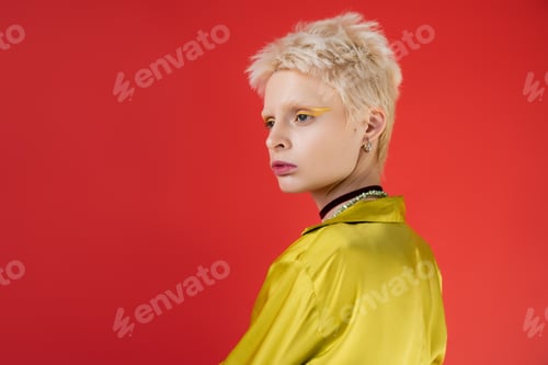 Preview: portrait of blonde albino woman with bright eyeliner looking away on carmine pink background