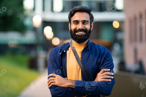 Preview: Portrait of cheerful bearded arabic guy posing in urban area