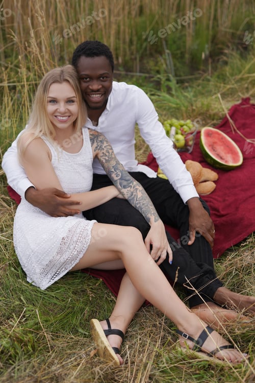 Preview: Multiethnic couple relaxing together outdoors in wheat fields