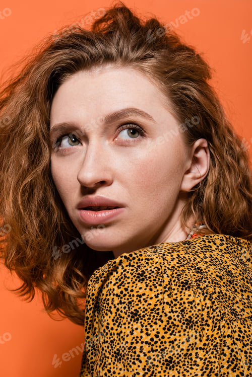 Preview: Portrait of young red haired woman with no-makeup look wearing yellow blouse with abstract pattern