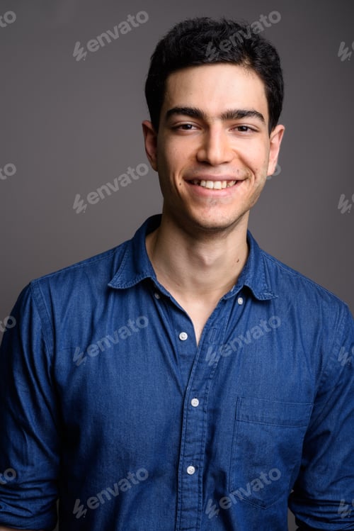 Preview: Portrait of young handsome businessman against gray background