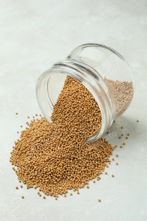 Preview: Glass jar with mustard seeds on white textured background