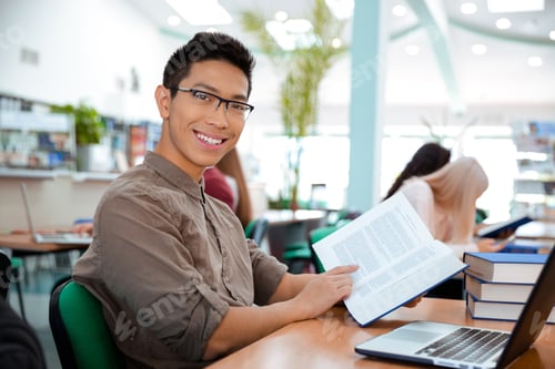 Preview: Portrait Of A Smiling Asian Man Sitting At The Table With Book In University