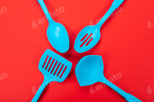 Preview: top view of blue kitchen utensils isolated on red background