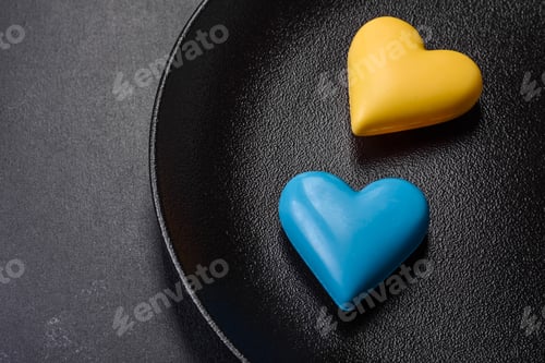 Preview: Chocolate hearts in the colors of the Ukrainian flag on a black ceramic plate