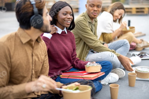 Preview: Students eating salad during lunch on asphalt