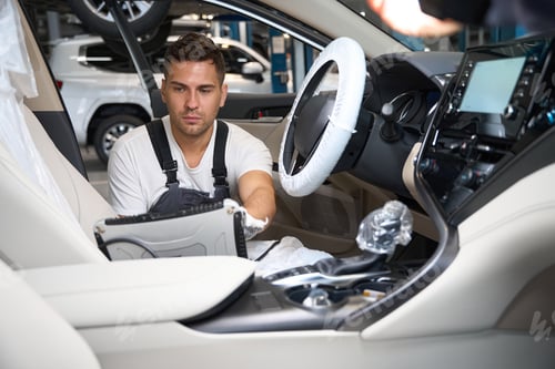 Preview: Male checking technical condition of car in the salon