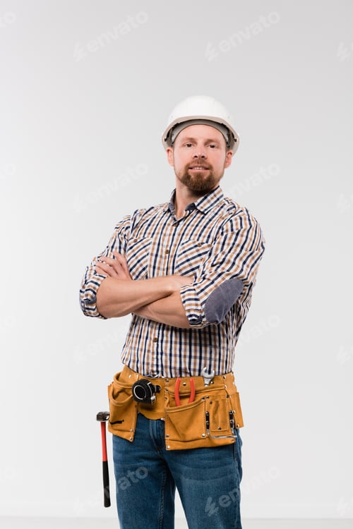 Preview: Young technician with toolbelt on his waist crossing arms by chest