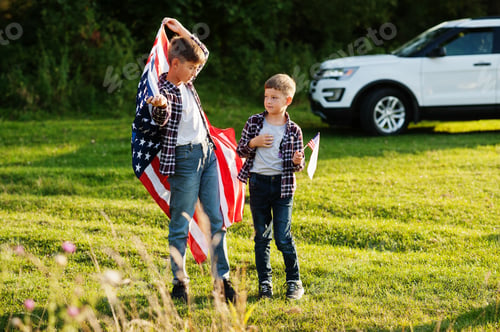 Preview: Two brothers with USA flag. America holiday. Proud to be children of country.
