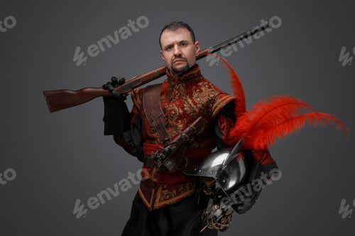 Preview: Stylish musketeer dressed in red costume holding rifle