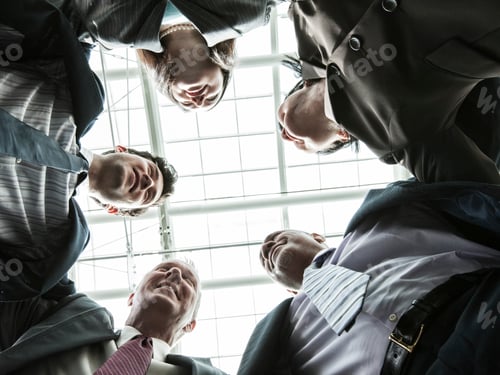 Preview: Mixed race group of business people standing in a team building circle.