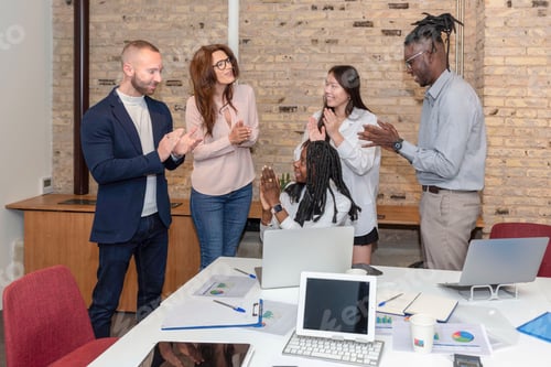 Preview: young multiethnic group of entrepreneurs working together applauding in a work office