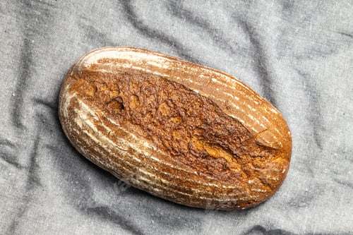 Preview: Loaf of bread on gray tablecloth.
