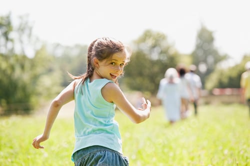 Preview: Germany, Bavaria, Girl running with family in background