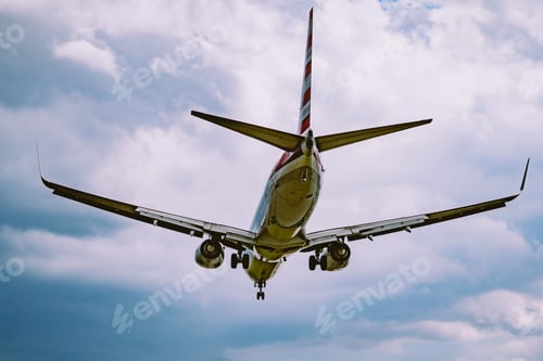 Preview: Low angle shot of an airplane flying in a cloudy sky
