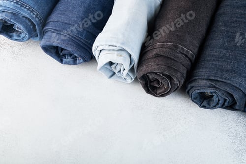 Preview: Row of different rolled jeans on white background