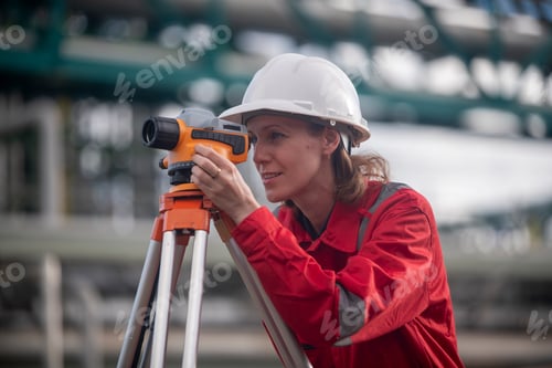 Preview: Surveyor engineers team wearing safety uniform and blueprint checking inspection by theodolite teles
