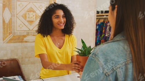 Preview: Female Customer Buying Plant From Sales Assistant In Independent Gift Store