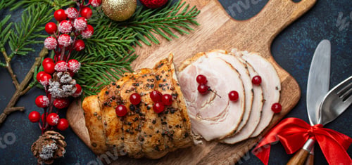 Preview: Christmas baked ham sliced with red berries and festive decorations