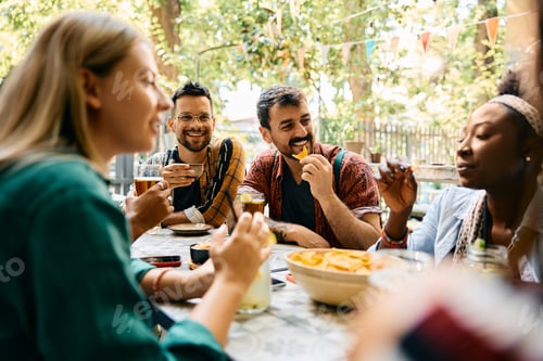 Preview: Happy man having fun while gathering with friends in a cafe.