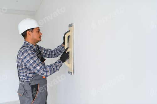 Preview: An Indian worker works in an empty apartment. A man in a uniform makes repairs inside the building