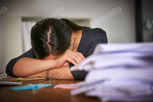 Preview: Shot of an unidentifiable businesswoman lying on her arms next to a pile of paperwork in the office