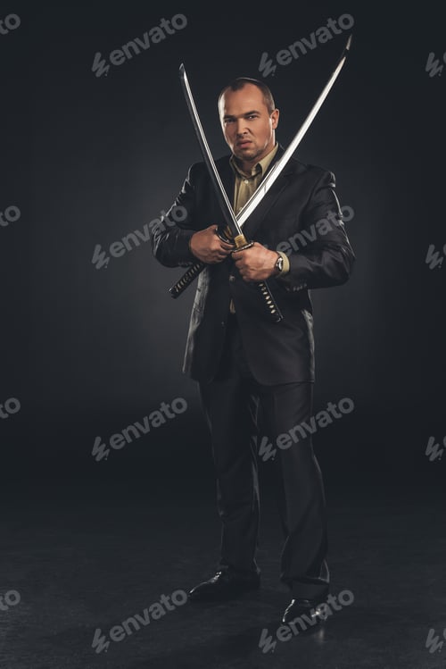 Preview: handsome man in suit with dual katana swords on black