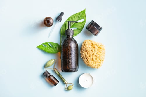 Preview: Natural skin care products on blue background, flat lay.