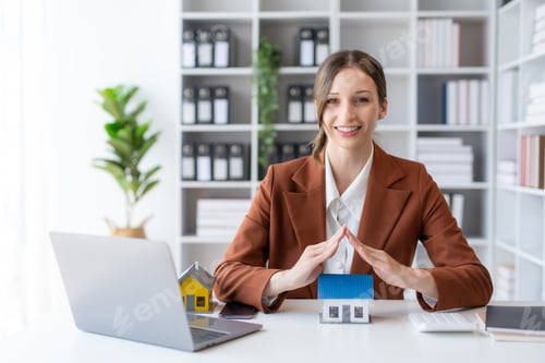 Preview: Agent female home sales and insurance sitting with laptop in office.